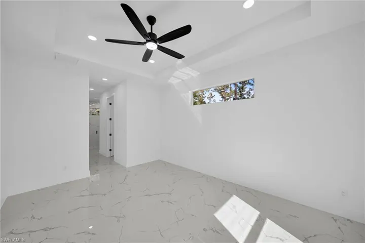 Empty room with recessed lighting, ceiling fan, and light marble finish floors
