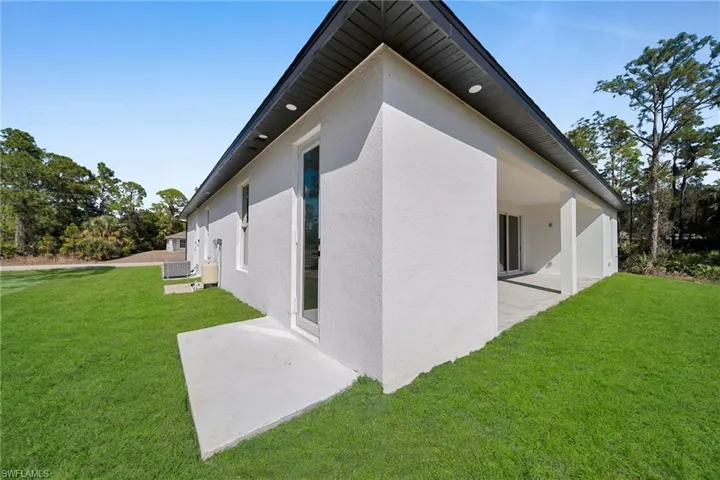 View of home's exterior featuring a lawn, a patio, and stucco siding