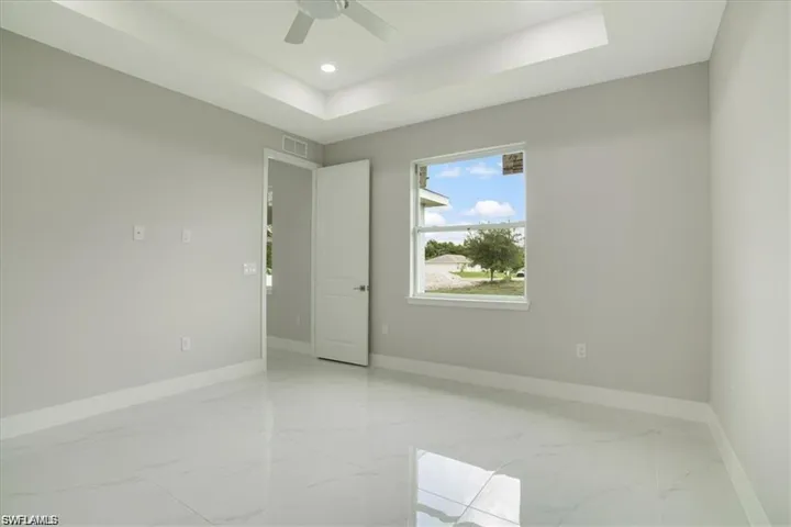 Empty room with a raised ceiling and ceiling fan