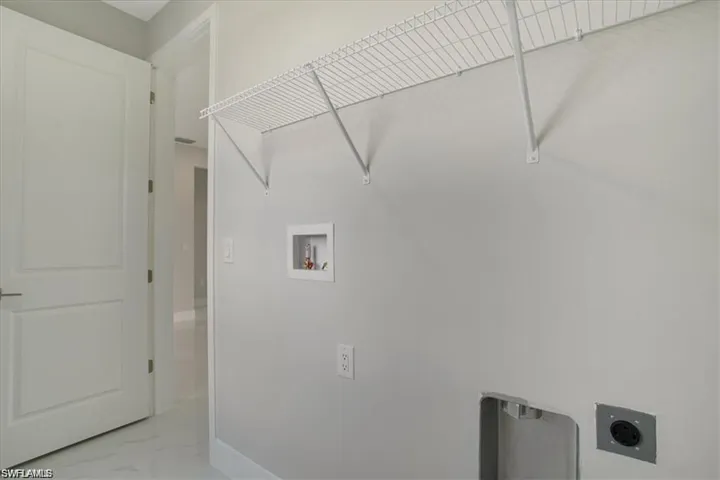 Clothes washing area featuring electric dryer hookup and washer hookup