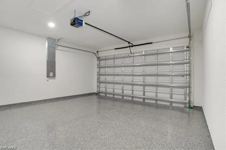 Garage featuring electric panel and a garage door opener