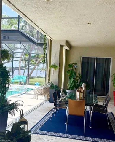 View of patio / terrace featuring a sunroom, outdoor dining space, glass enclosure, and an outdoor pool