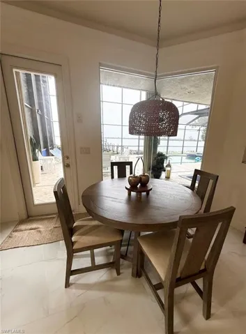 Dining space featuring healthy amount of natural light and light marble finish flooring