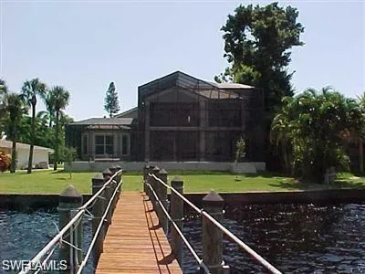 Dock area with a water view and a lawn