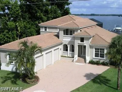 Mediterranean / spanish-style home with a tile roof, stucco siding, an attached garage, driveway, and a front yard