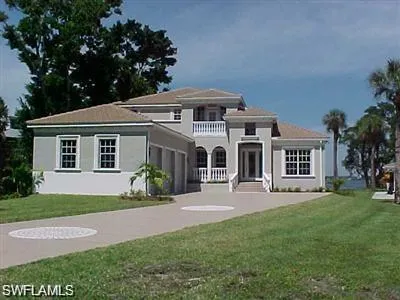 View of front facade featuring a front yard, driveway, and stucco siding