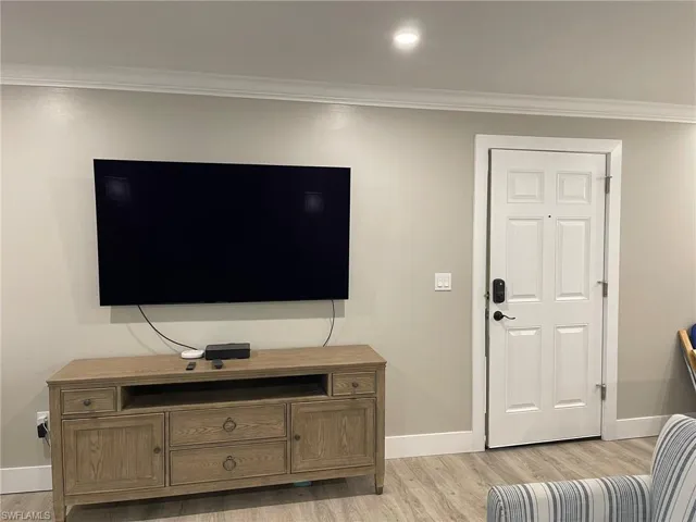 Living area with crown molding, light wood finished floors, and recessed lighting