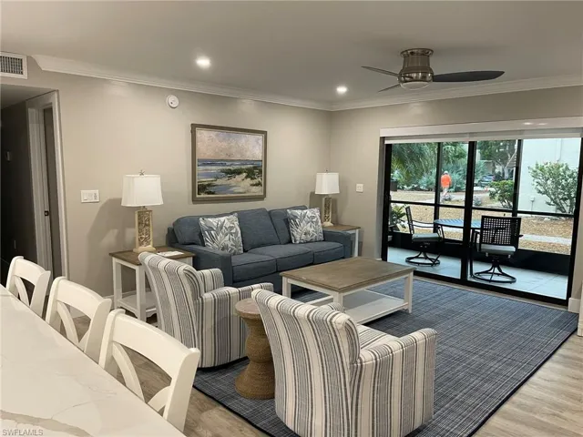 Living area with ornamental molding, recessed lighting, wood finished floors, and a ceiling fan