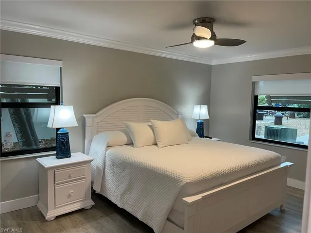 Bedroom with crown molding, wood finished floors, and ceiling fan