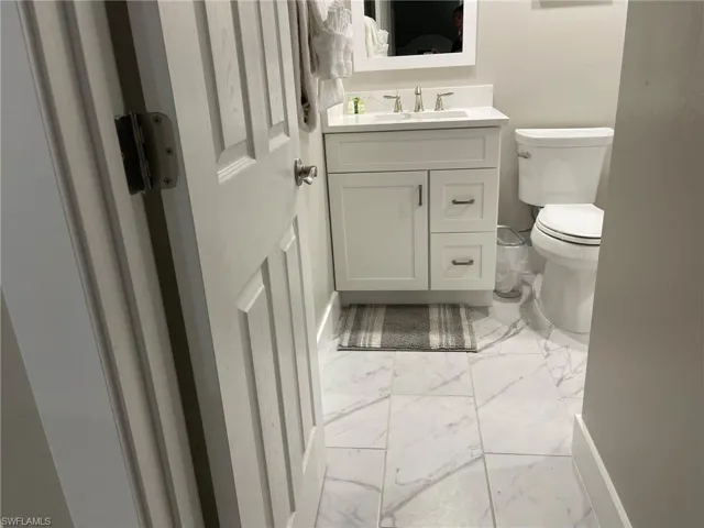 Bathroom with light marble finish flooring and vanity