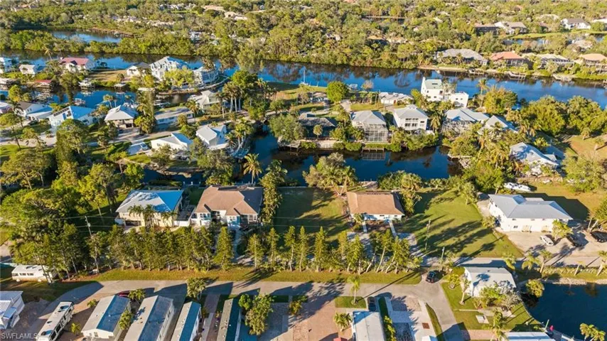 Aerial view of property and surrounding area featuring nearby suburban area and a large body of water