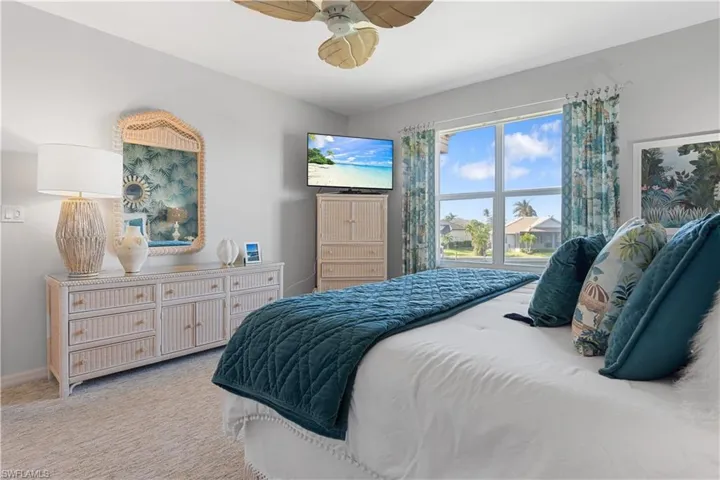 Carpeted bedroom featuring ceiling fan