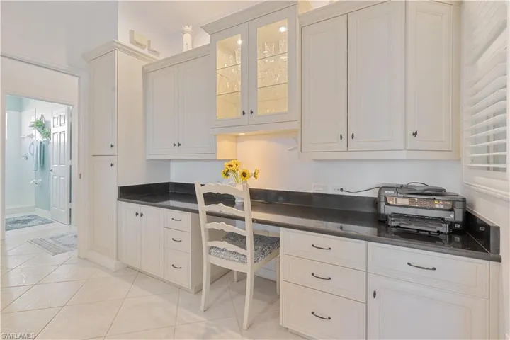 Office area featuring built in desk and light tile patterned floors