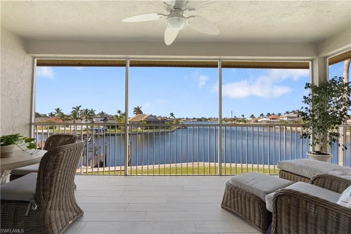 Sunroom / solarium featuring a water view and ceiling fan