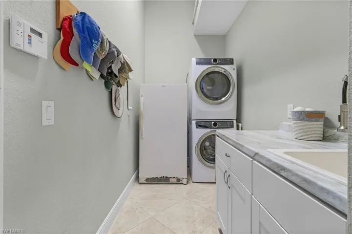 Laundry between the 3-car garage and living.  The freezer does not convey.