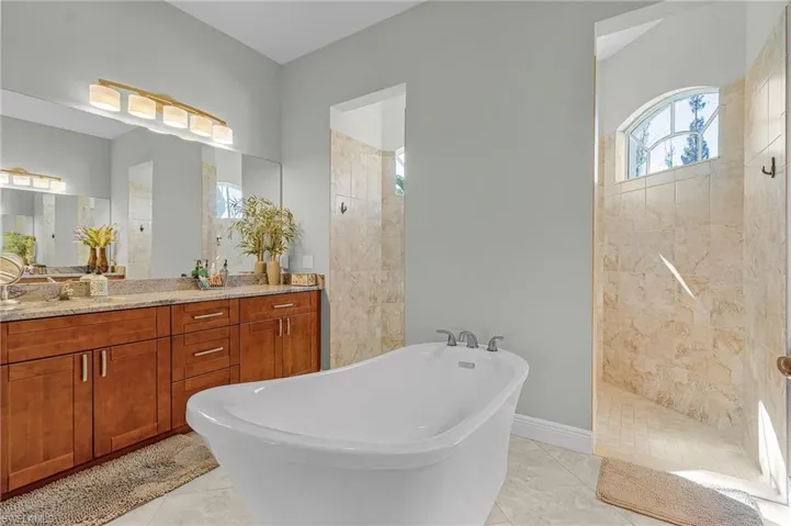 Primary Bathroom with counter for him, soaking tub, and walk-through shower.