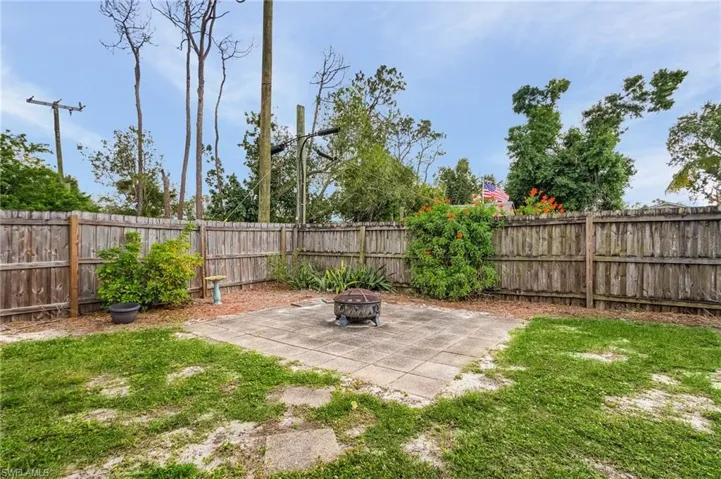 fire pit in corner of the fenced yard.