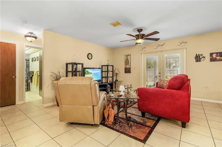 Living room has French doors to the lanai. Through the doorway to the left is the guest bath and 2 bedrooms