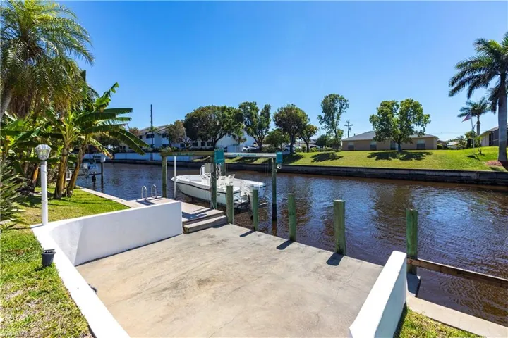 View of dock with boat lift, water and Electric on Dock