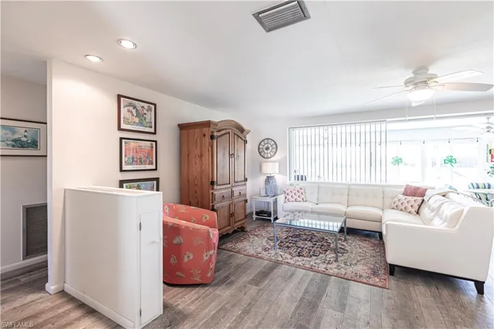 Living room with recessed lighting, ceiling fan, and wood laminated floors