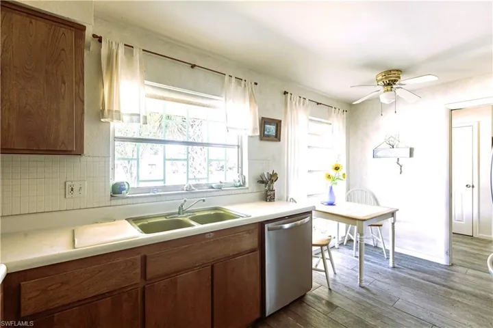 Kitchen featuring new dishwasher, light countertops, wood finished floors, and a sink