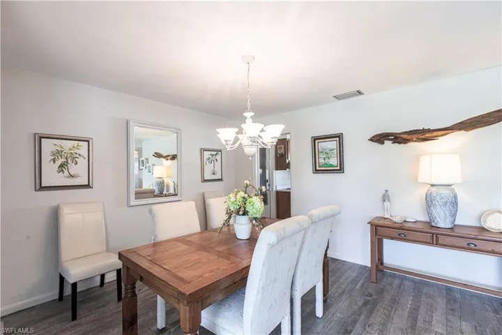 Dining area with laminate wood finished floors, baseboards and chandelier. Stunning views
