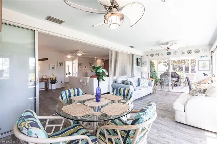 Extra large Sunroom with Dining area and sitting Area featuring  a ceiling fan, and wood finished floors, Wall of Glass