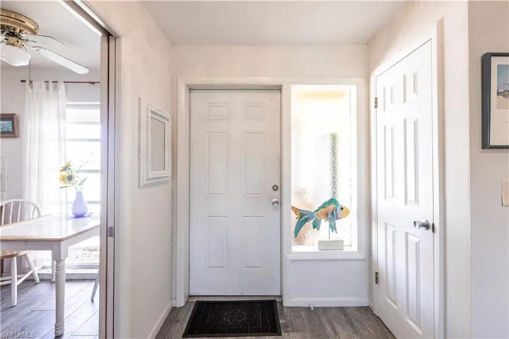 Foyer featuring ceiling fan, baseboards, and wood laminated floors