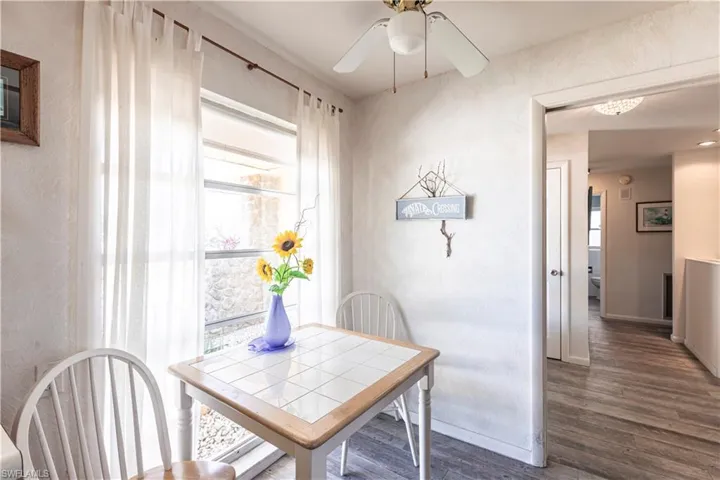 Eat In Kitchen featuring a healthy amount of sunlight, a ceiling fan, wood laminate flooring, and great sunlight