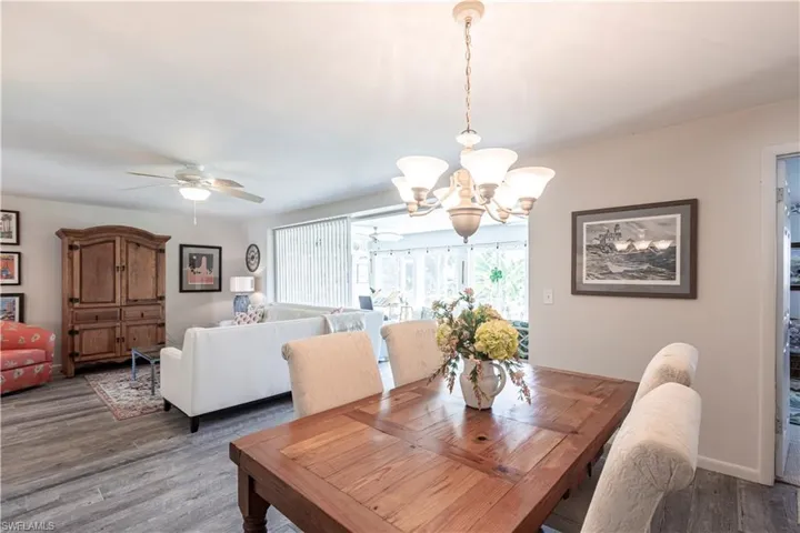 Dining room with ceiling fan with chandelier, baseboards, and wood finished floors. Great Views