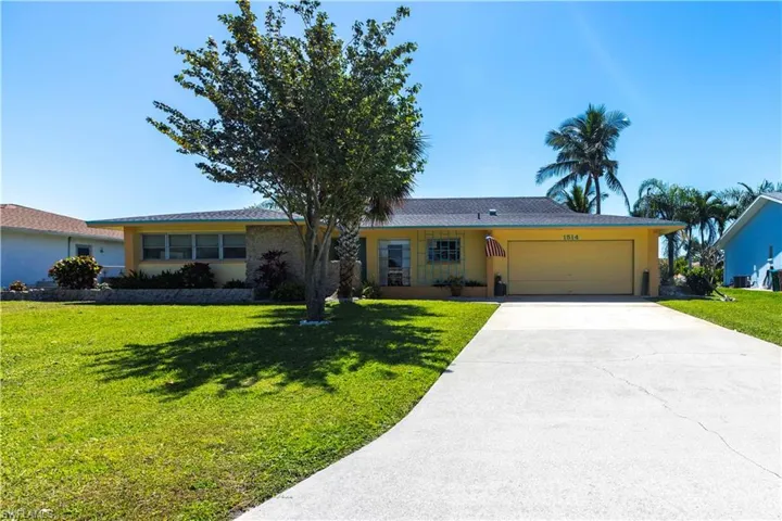 Ranch-style home with a garage, a front yard, driveway, and stucco siding. New roof
