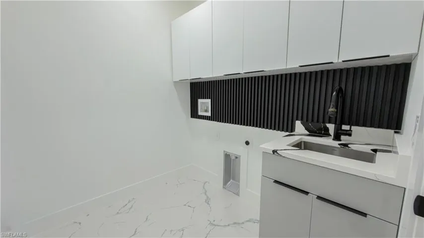 Laundry room with light marble finish floors, cabinet space, electric dryer hookup, and hookup for a washing machine