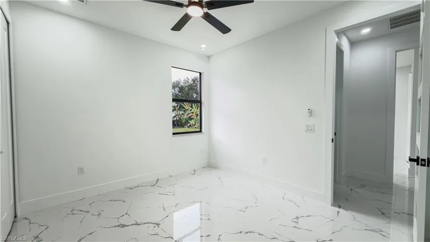 Unfurnished room with light marble finish floors, ceiling fan, and recessed lighting
