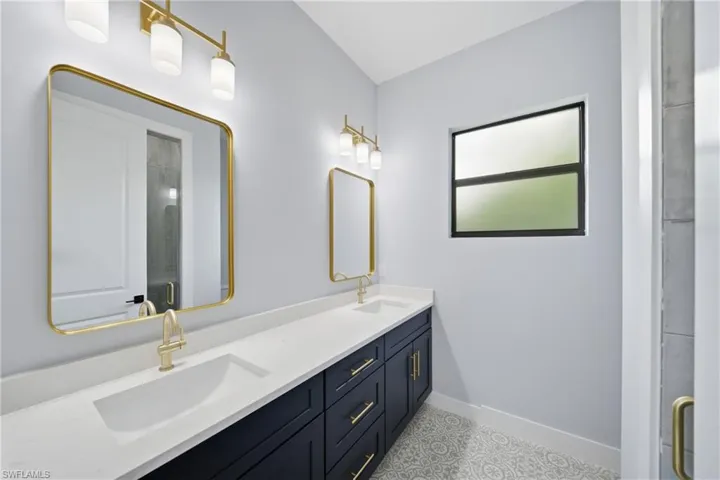 Bathroom featuring double vanity and a shower stall