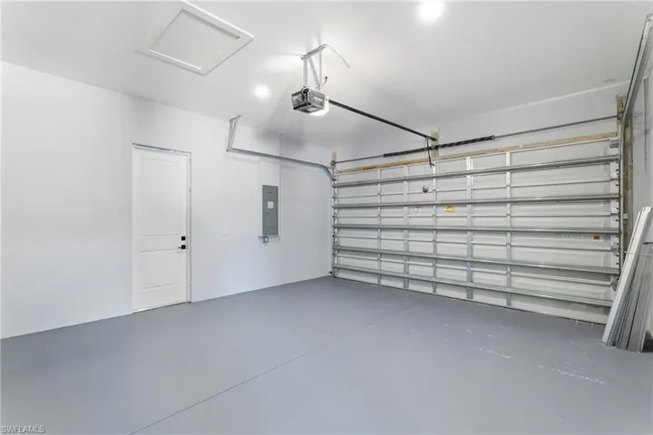 Garage with electric panel and a garage door opener