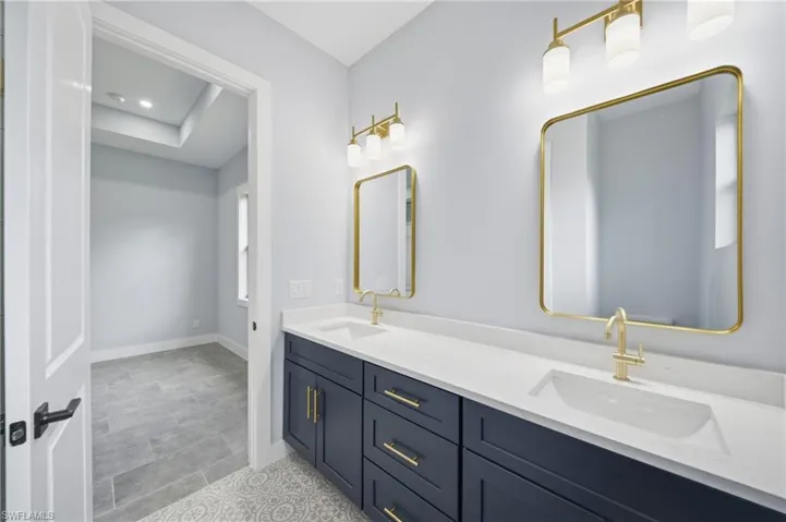Bathroom featuring double vanity and baseboards