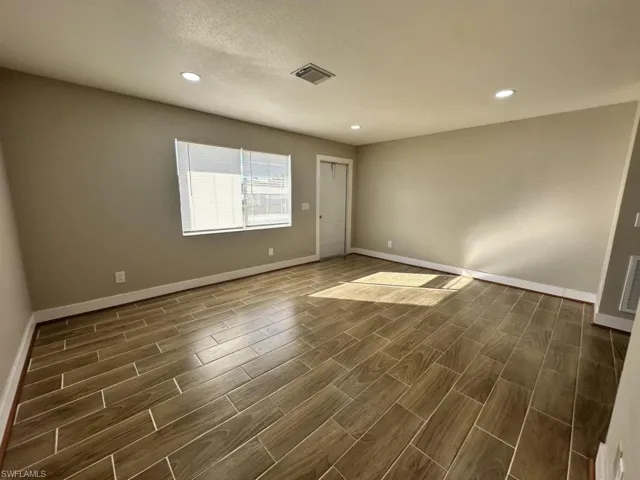 Unfurnished room with wood tiled floors and recessed lighting