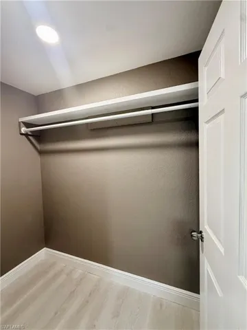 Walk in closet with light wood-style floors