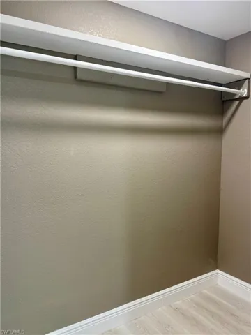 Walk in closet with light wood-type flooring