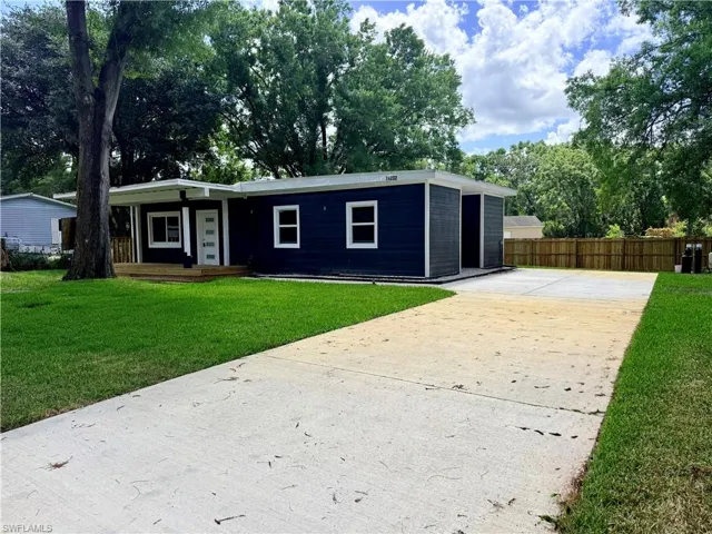 View of front facade featuring concrete driveway and a wooden deck
