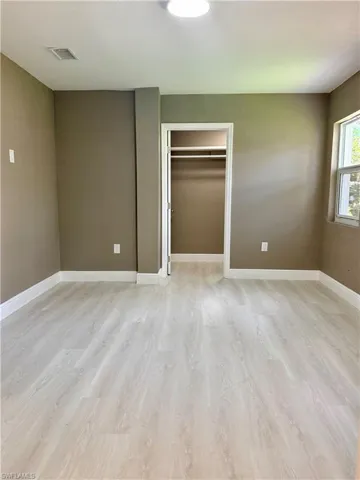 Unfurnished bedroom with light wood-style floors and a closet