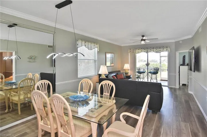 Dining room with wood finished floors, crown molding, plenty of natural light, and ceiling fan