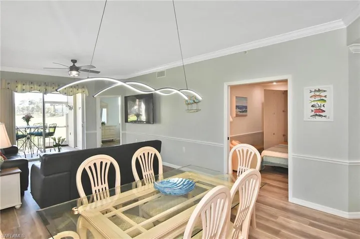 Dining room featuring ceiling fan, wood finished floors, and crown molding