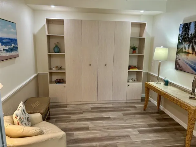 Queen Murphy bed & Sitting room with light wood-style floors and built in features