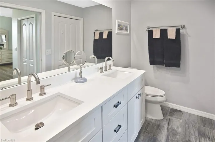 Full bath featuring double vanity and toilet