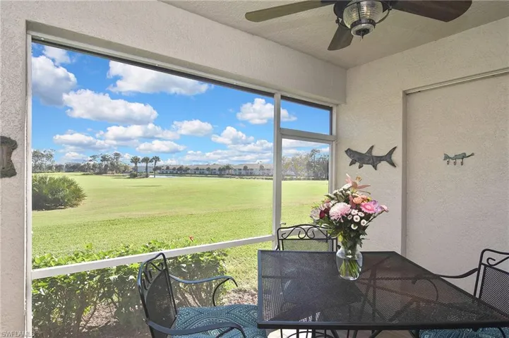 Sunroom / solarium featuring ceiling fan, golf course view, and outdoor dining area