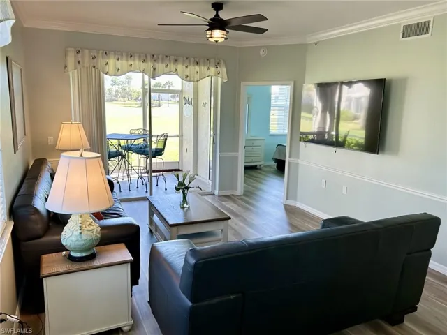 Living area with ornamental molding, ceiling fan, and wood finished floors