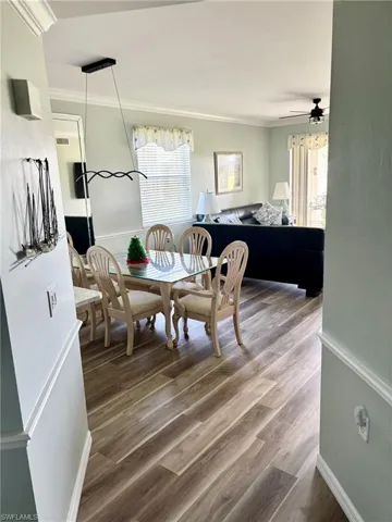 Dining area featuring ornamental molding, wood finished floors, and a ceiling fan