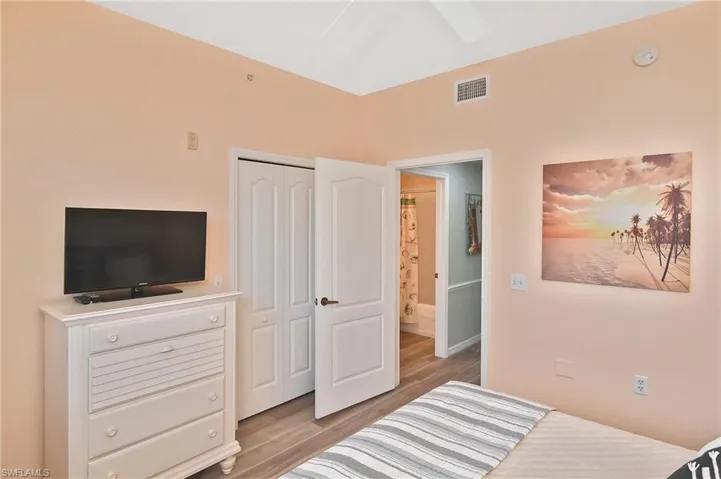 Bedroom with light wood-type flooring, a closet, and a ceiling fan