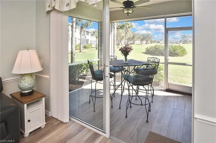 Sunroom with a ceiling fan, view of golf course, and outdoor dining space